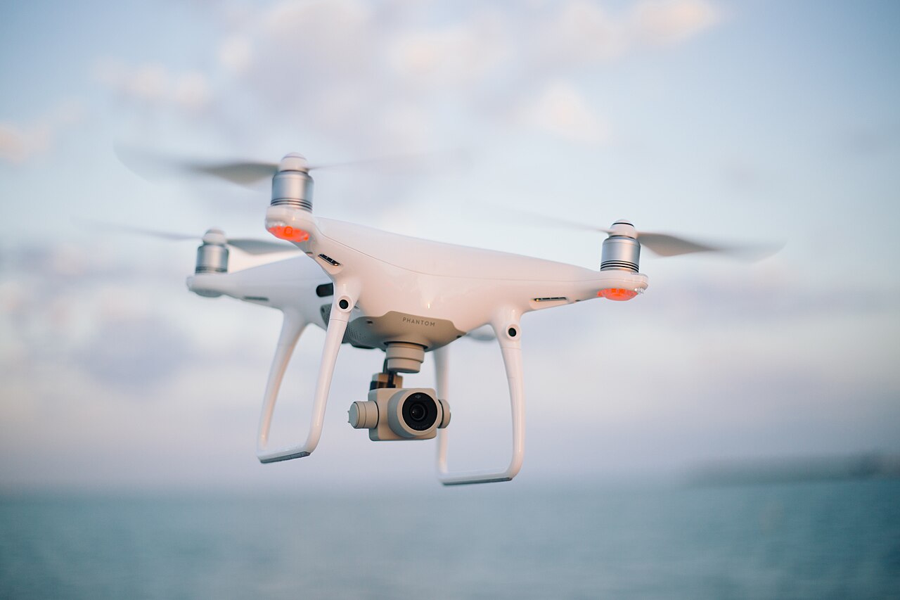 Drone avec caméra en vol stationnaire au-dessus de la mer